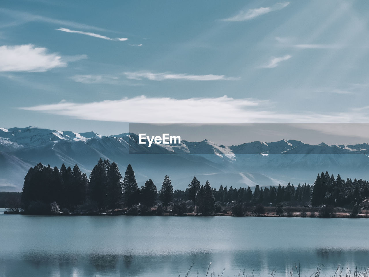 Scenic view of lake by mountains against sky