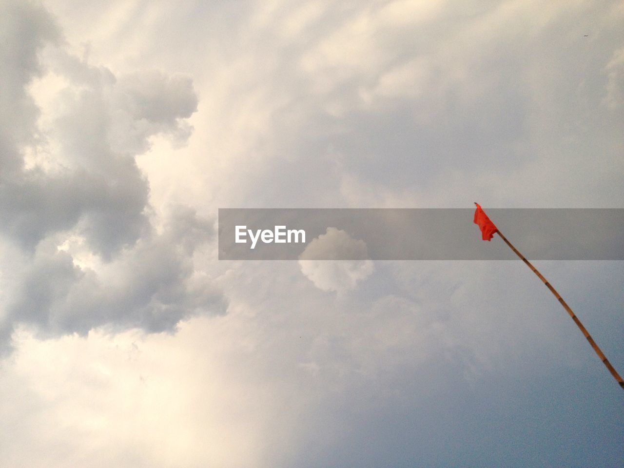 LOW ANGLE VIEW OF RED FLAG AGAINST SKY