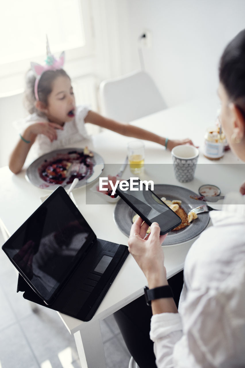 Woman using cell phone at table