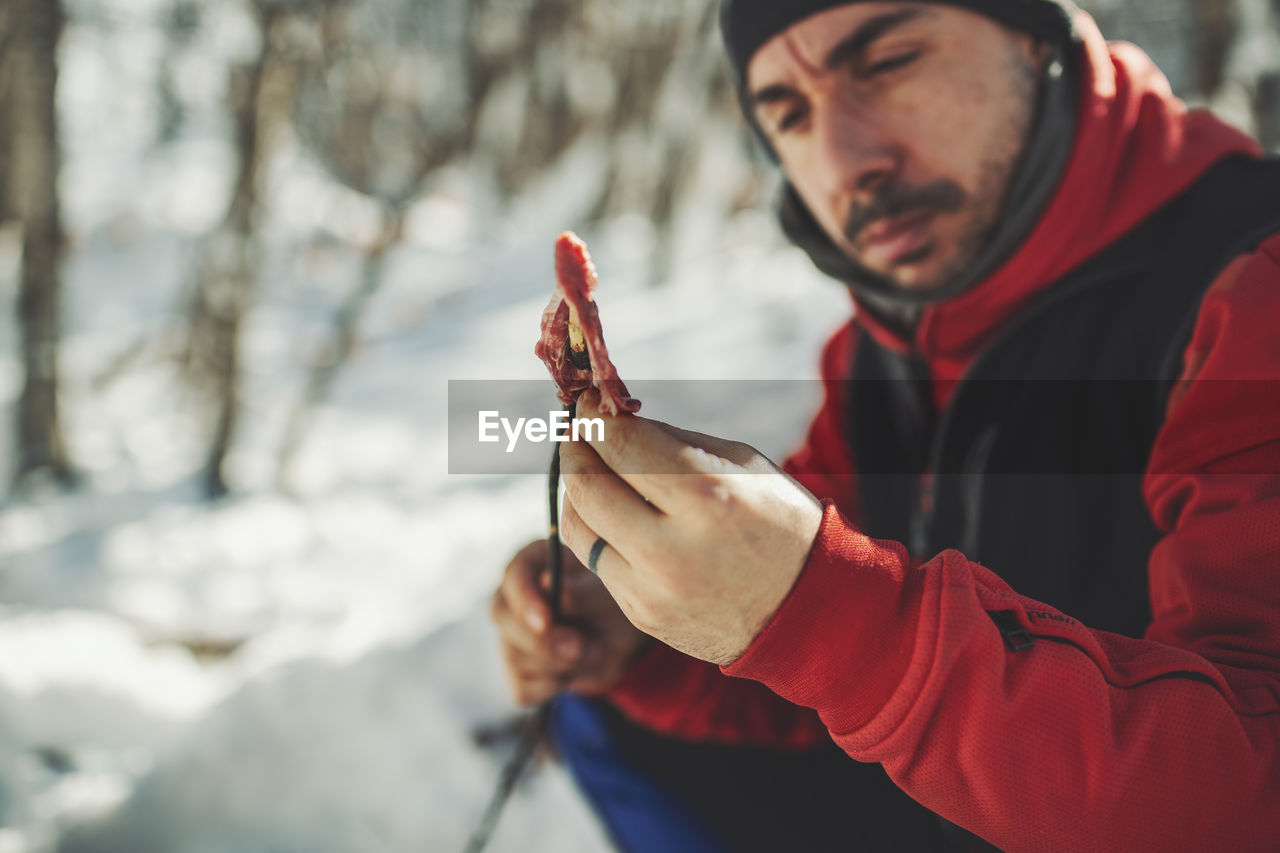 Close-up of man preparing meat during winter