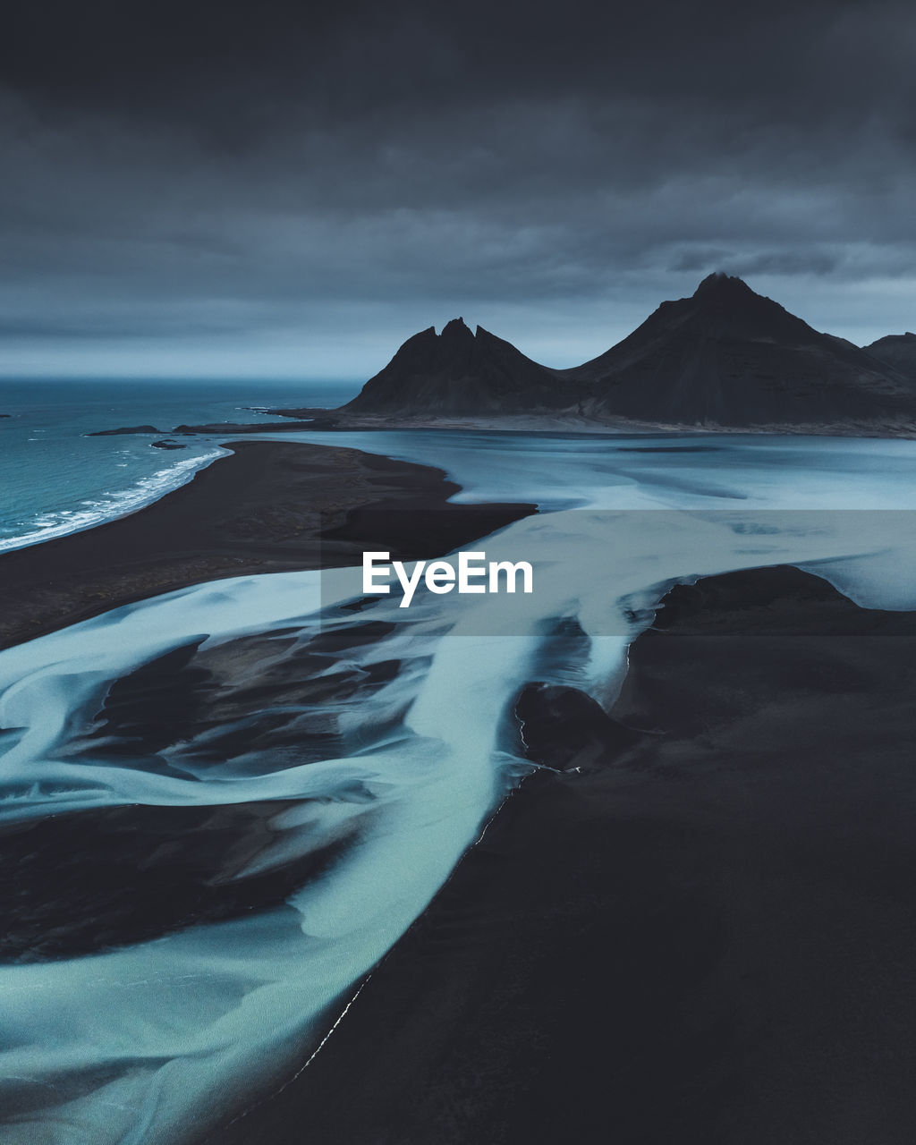 Scenic view of sea and mountains against sky