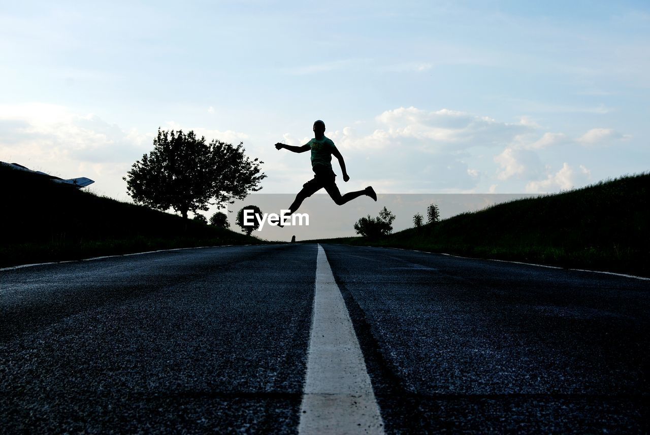 LOW SECTION OF PERSON SKATEBOARDING ON ROAD