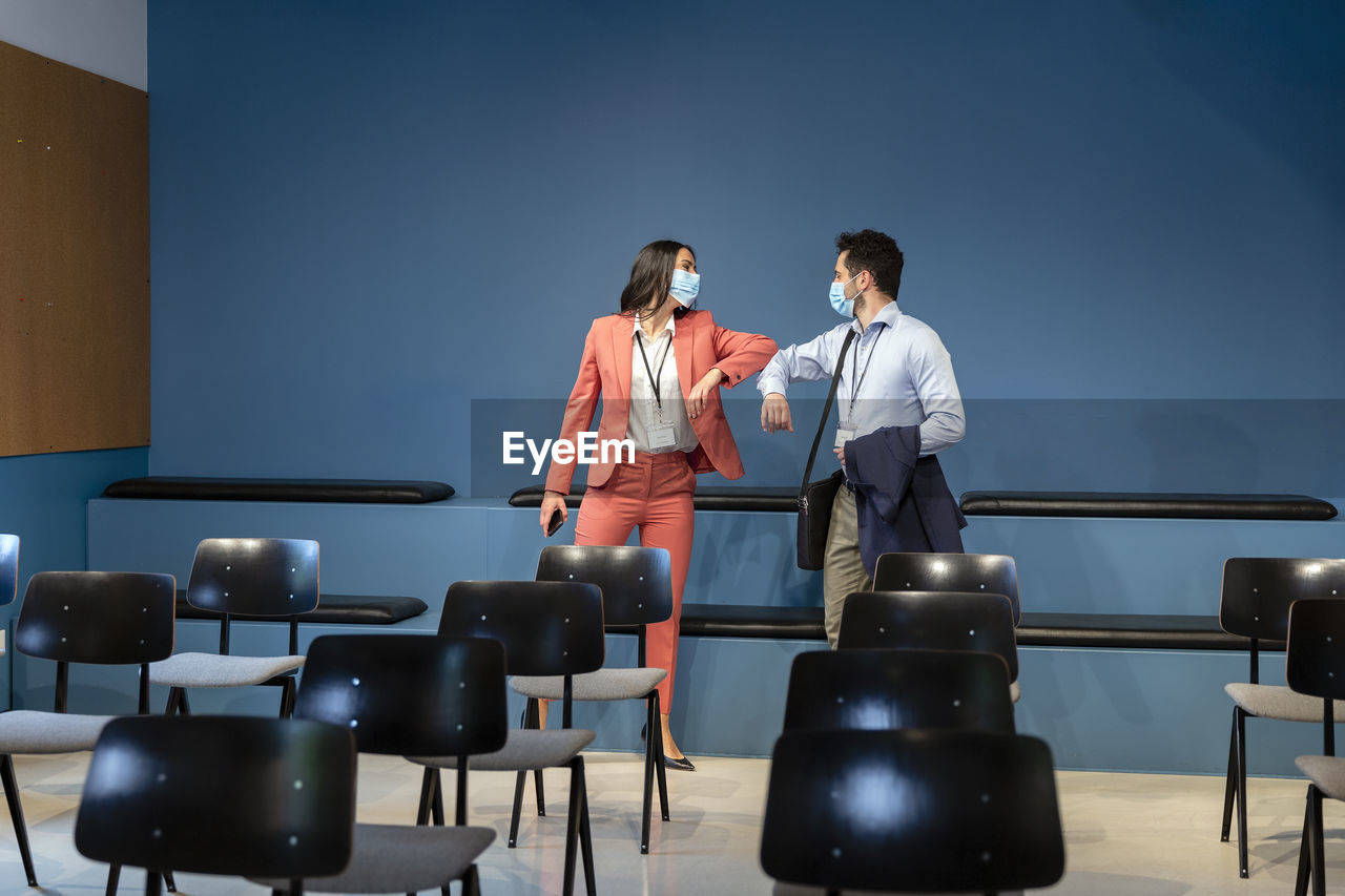 Business colleagues bumping elbows in office board room