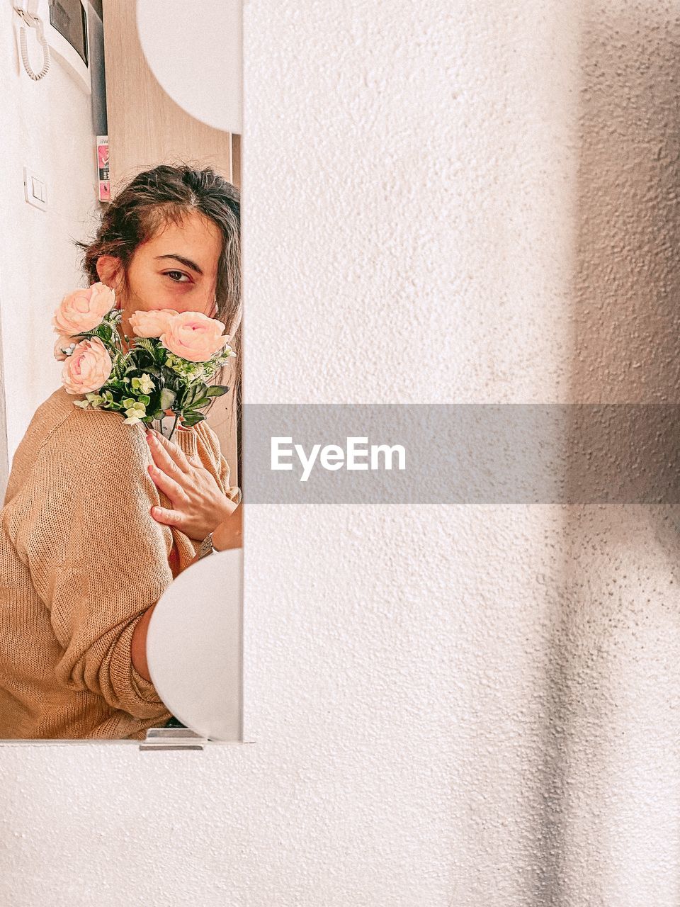 Self-portrait at the mirror holding some flowers