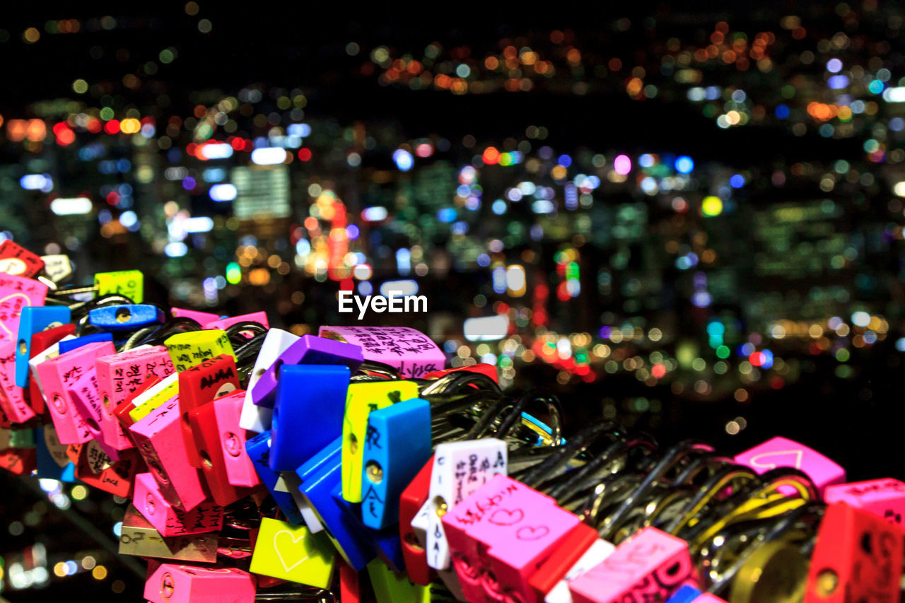 CLOSE-UP OF PADLOCKS ON ILLUMINATED CITY