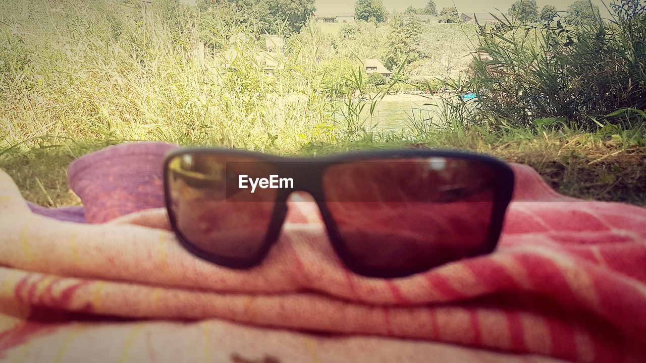 CLOSE-UP OF MAN WEARING SUNGLASSES ON TABLE