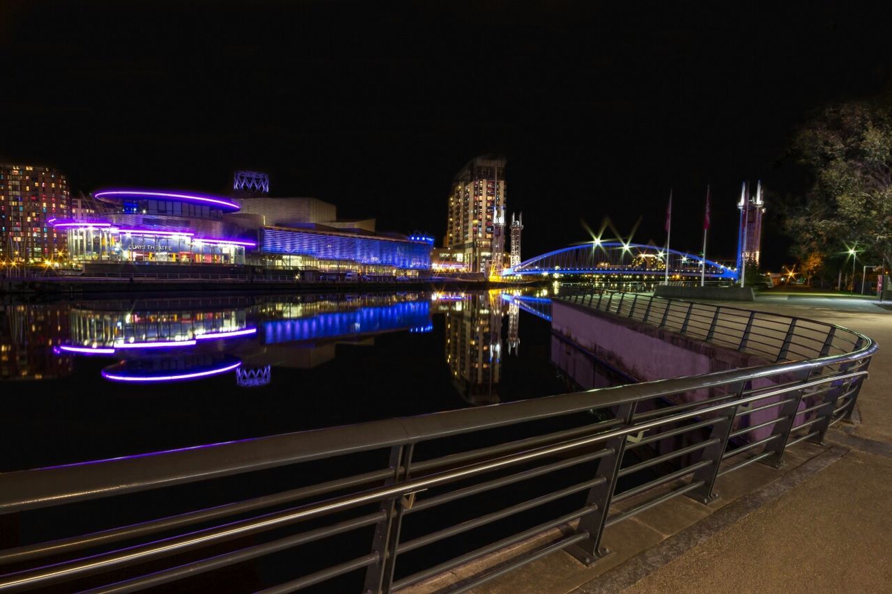 Illuminated buildings at night with waterfront