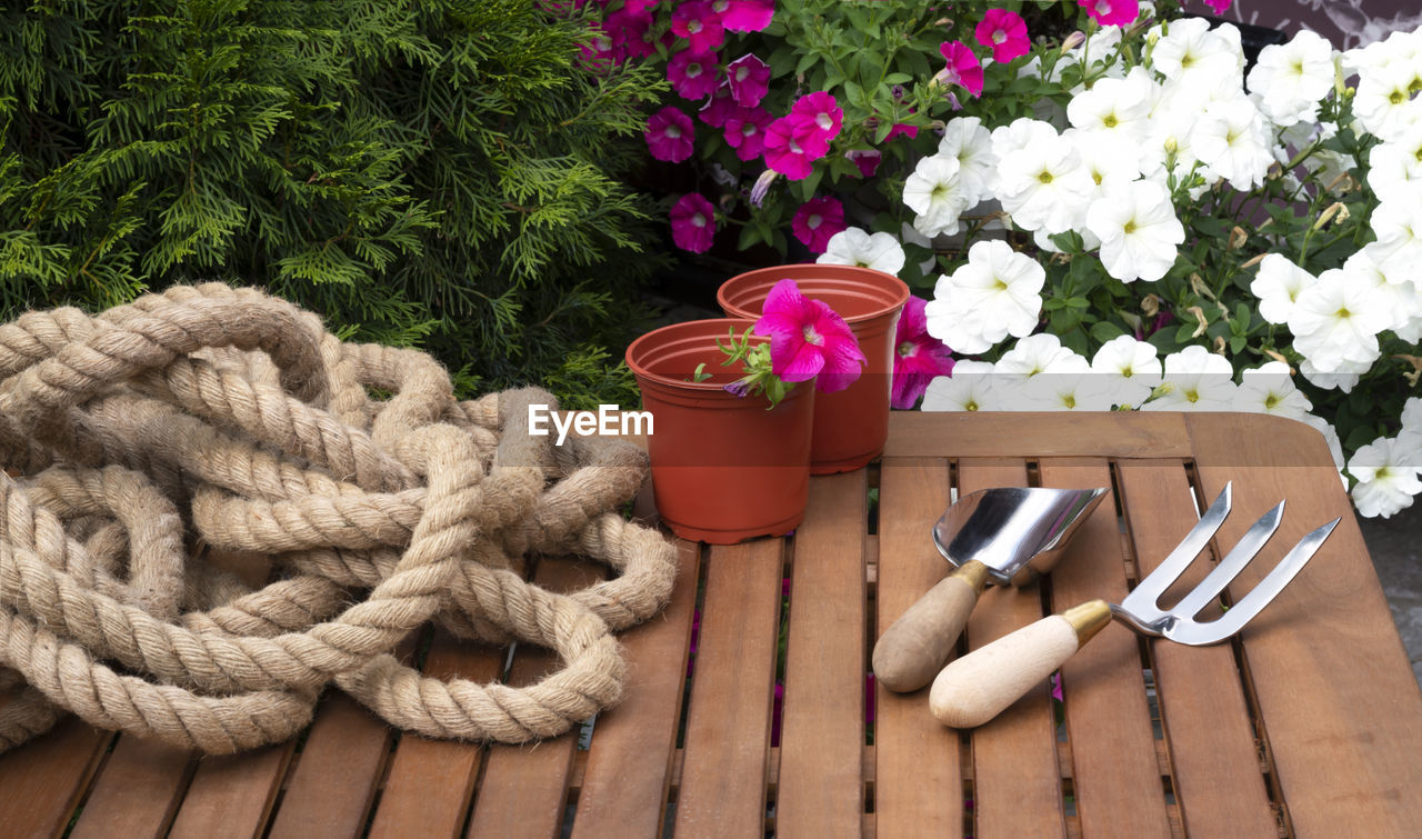 Gardening equipment. trowel or shovel, garden fork and flower pots on a wooden table in the garden.