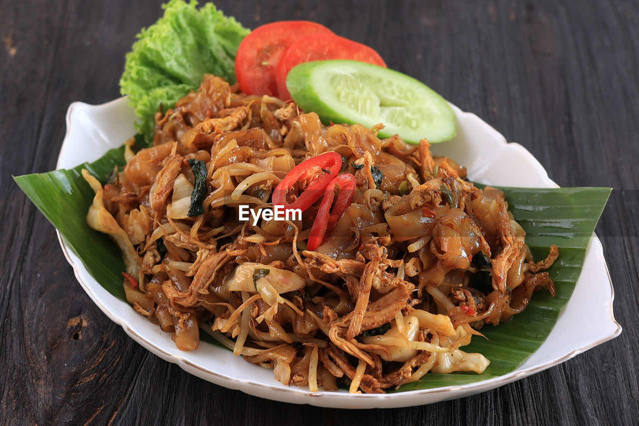 Kwetiaw or kwetiau, fried rice flat noodles with chicken, meatballs, and various vegetables.