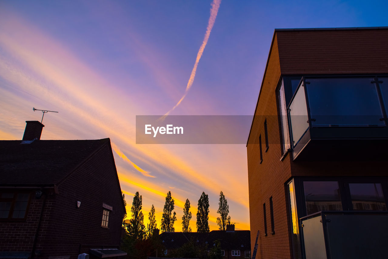 LOW ANGLE VIEW OF BUILDING AGAINST SKY AT SUNSET