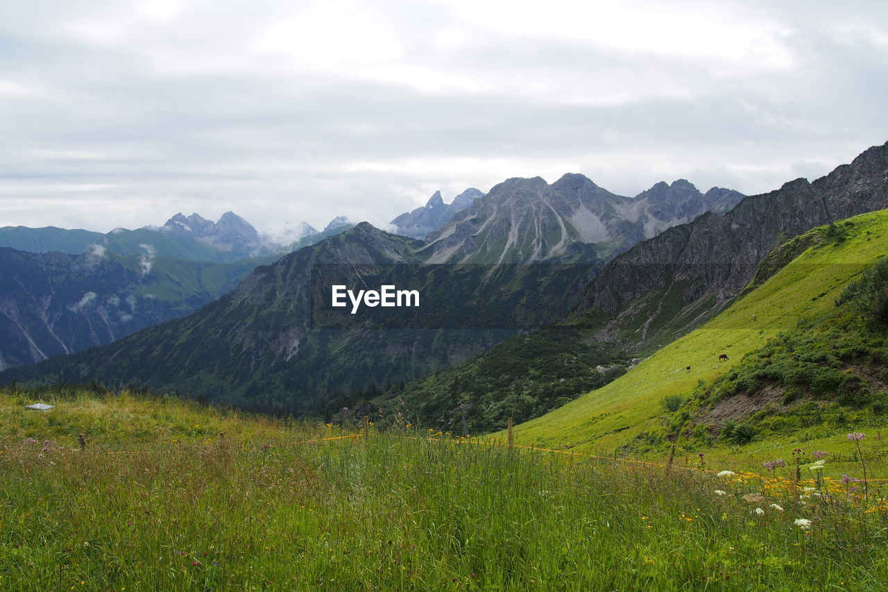 Scenic view of mountains against cloudy sky