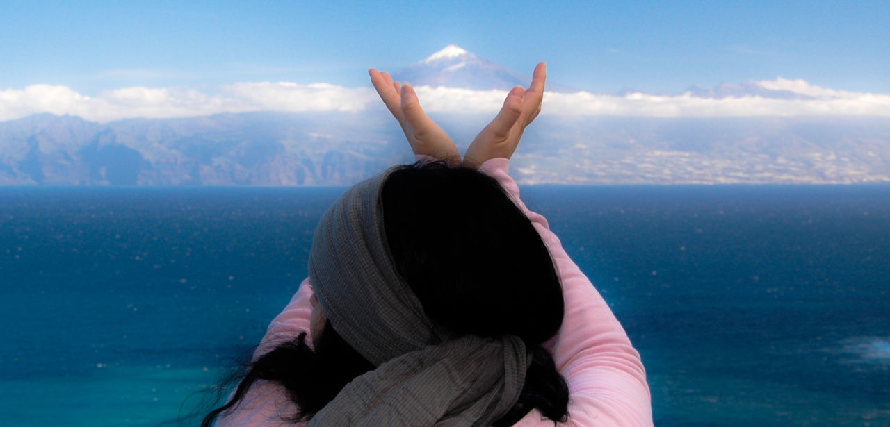 Optical illusion of woman holding el teide volcano