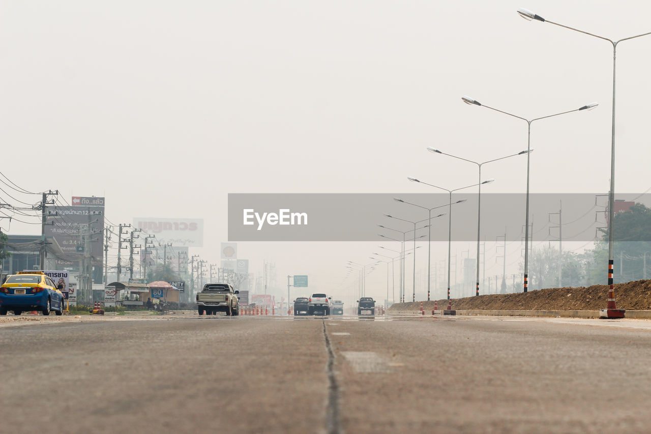 VEHICLES ON ROAD AGAINST CLEAR SKY