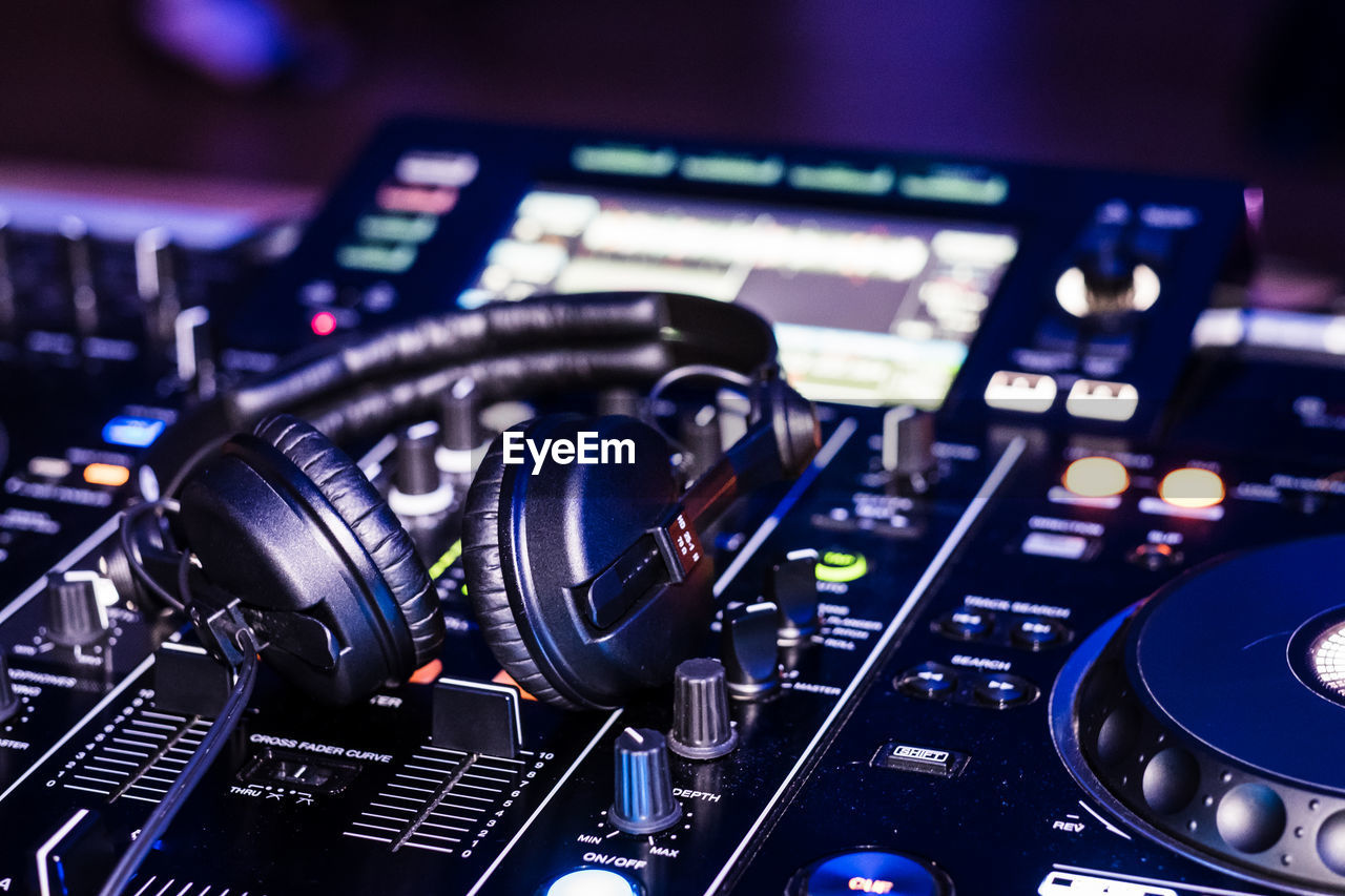 Close-up of headphones on sound mixer at nightclub