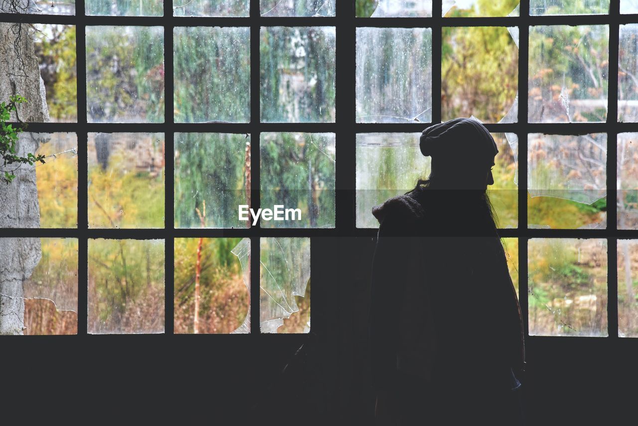 Thoughtful woman standing against window