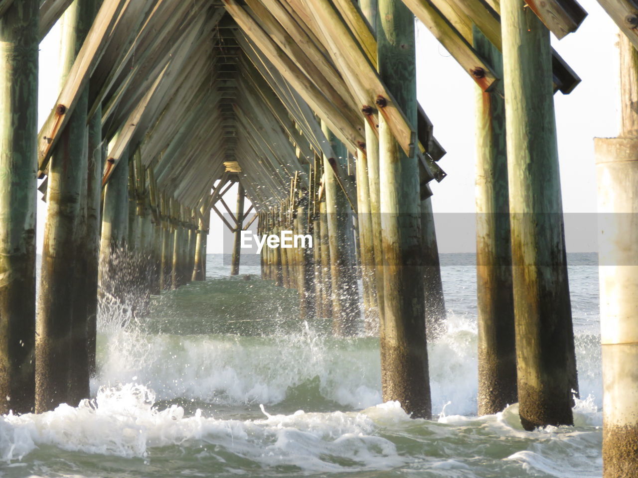 Water splashing over columns of pier on sea
