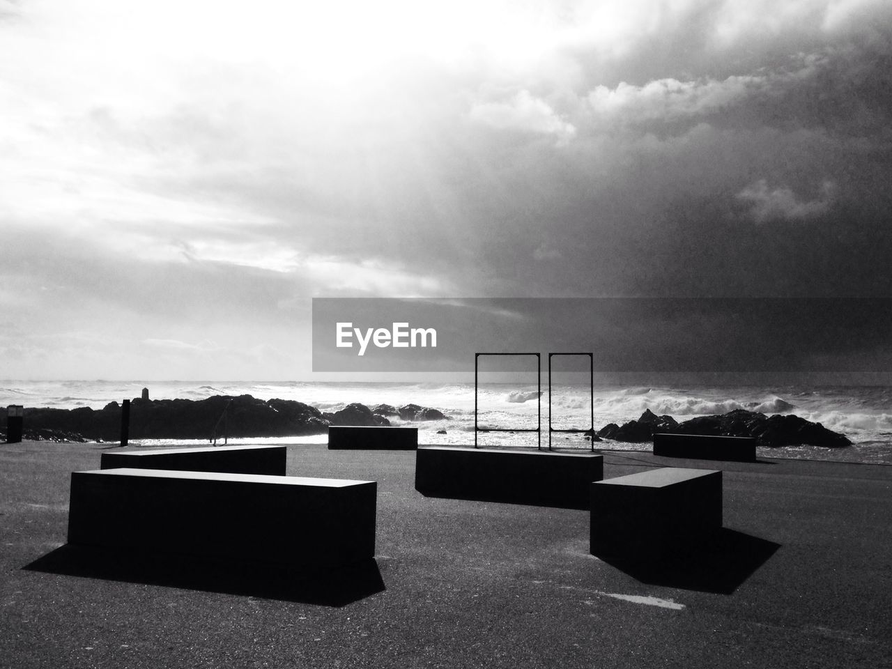 Empty seats on beach against sky