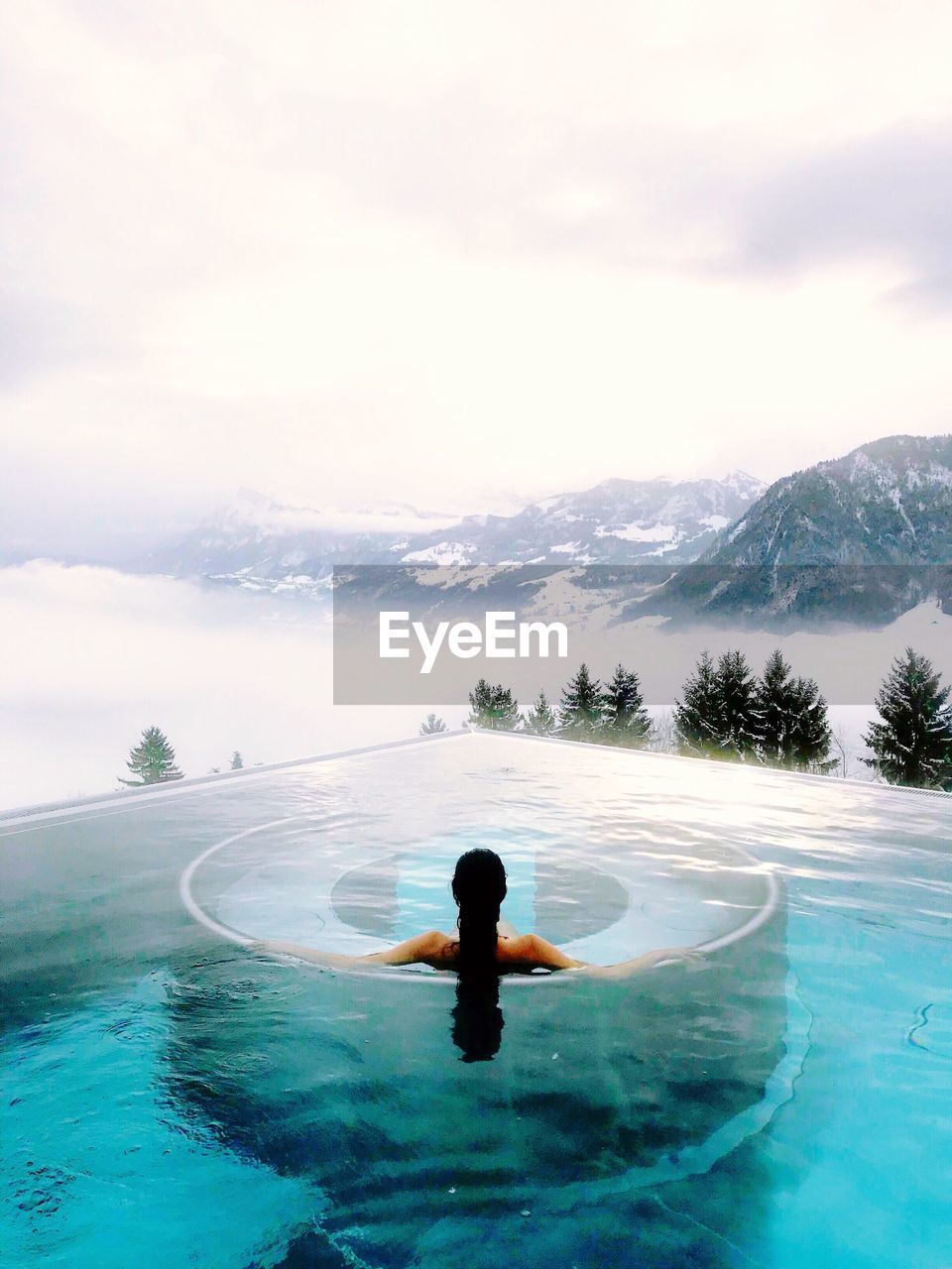 High angle view of woman in swimming pool against mountains