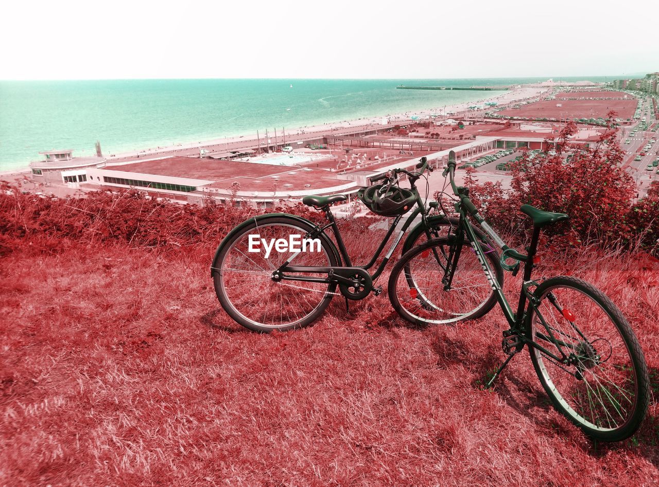 BICYCLES ON BEACH AGAINST SEA