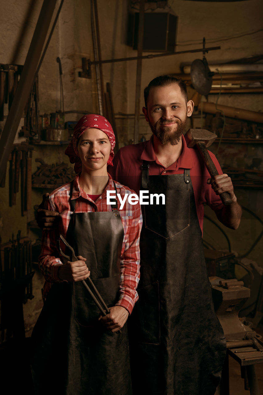 Portrait of blacksmiths standing in workshop