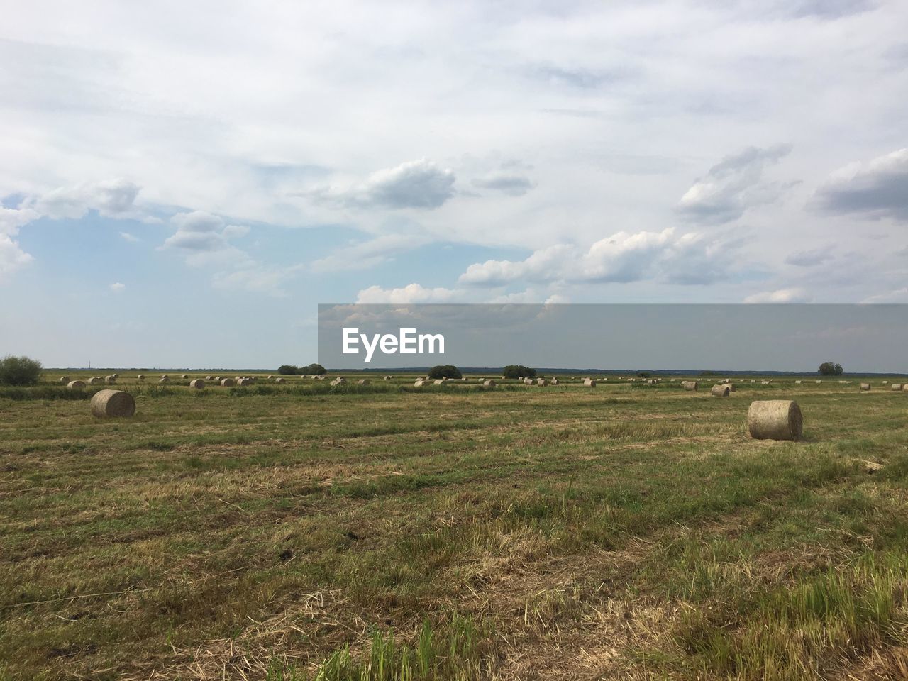 Hay bales on field against sky