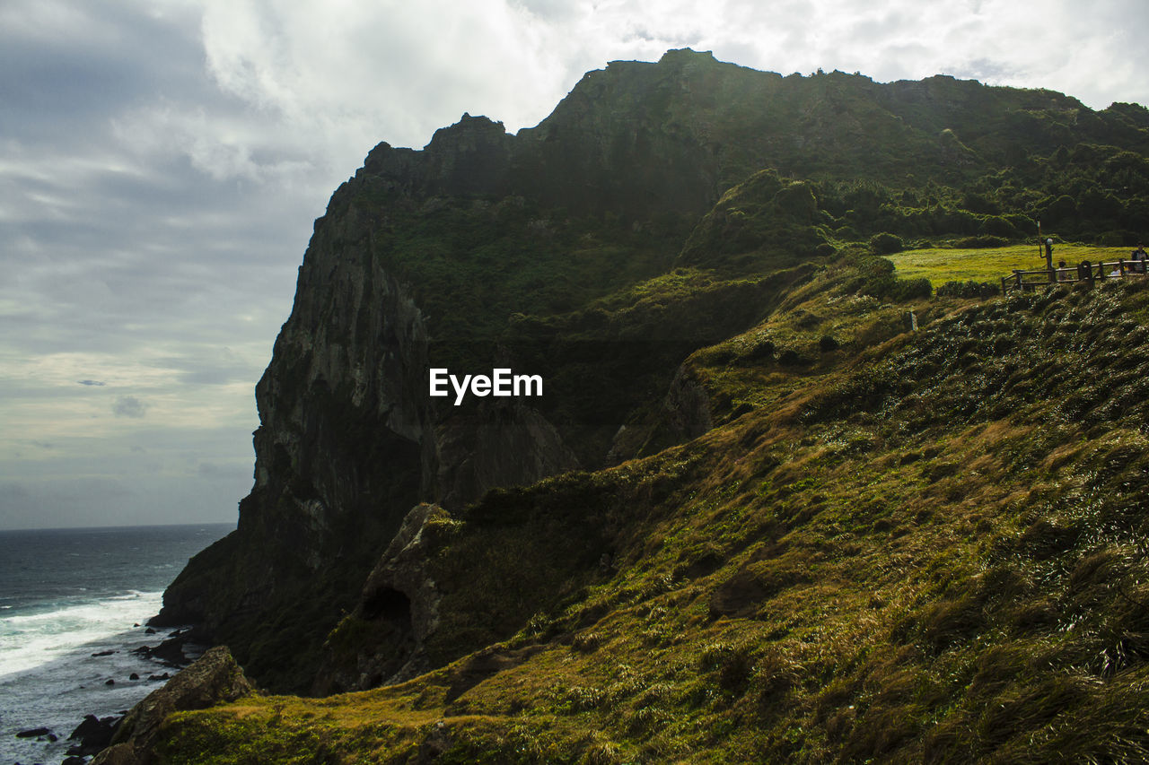 Scenic view of sea and mountains against sky