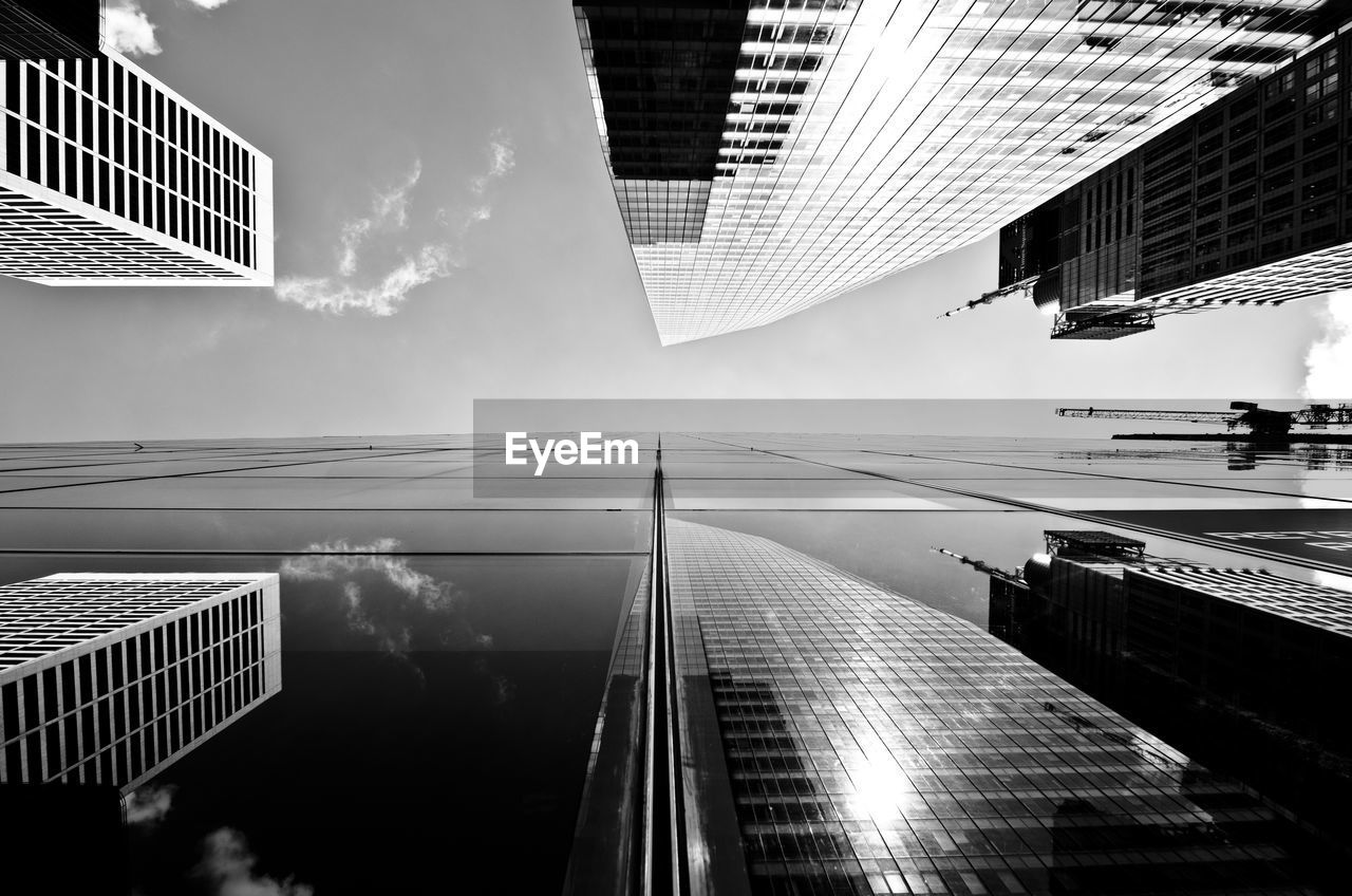 DIRECTLY BELOW SHOT OF MODERN BUILDINGS IN CITY AGAINST SKY