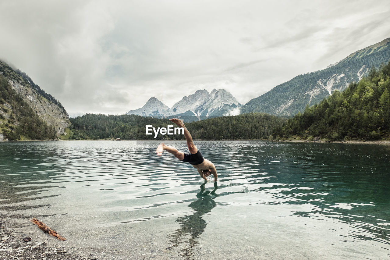 Tourist diving in blindsee lake by mieming range, tirol, austria