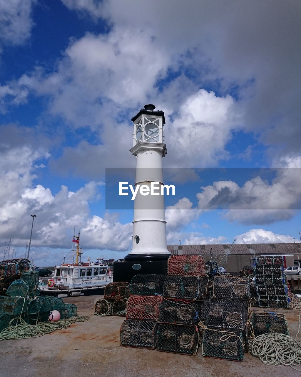 Lighthouse and crab pots against sky