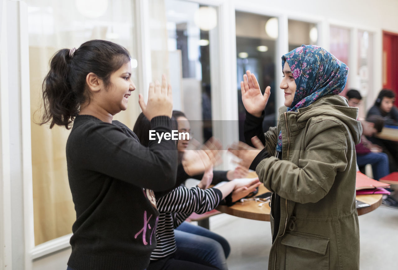 Teenage girls playing in classroom