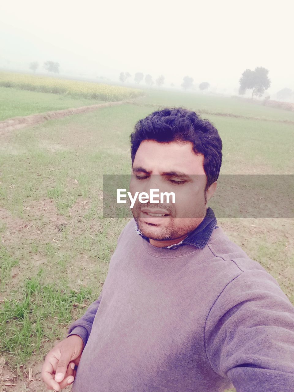 PORTRAIT OF YOUNG MAN ON FIELD