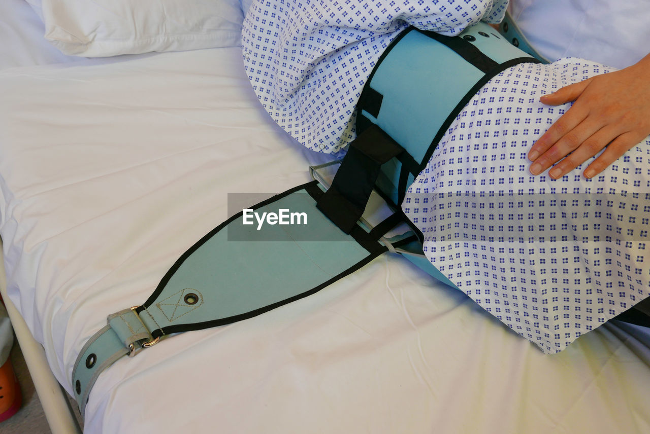 Cropped person lying in hospital bed