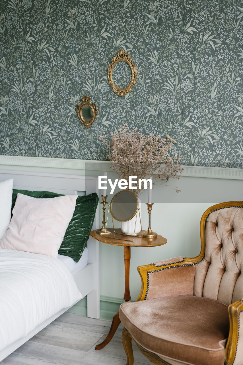 Interior of the scandinavian provence bedroom. pillows on the bed, a wooden table on a leg