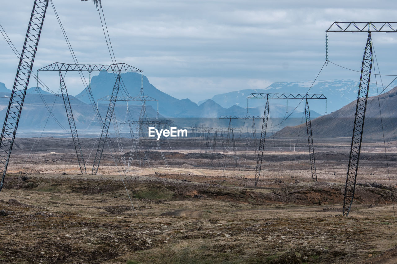 Electricity pylon on land against sky