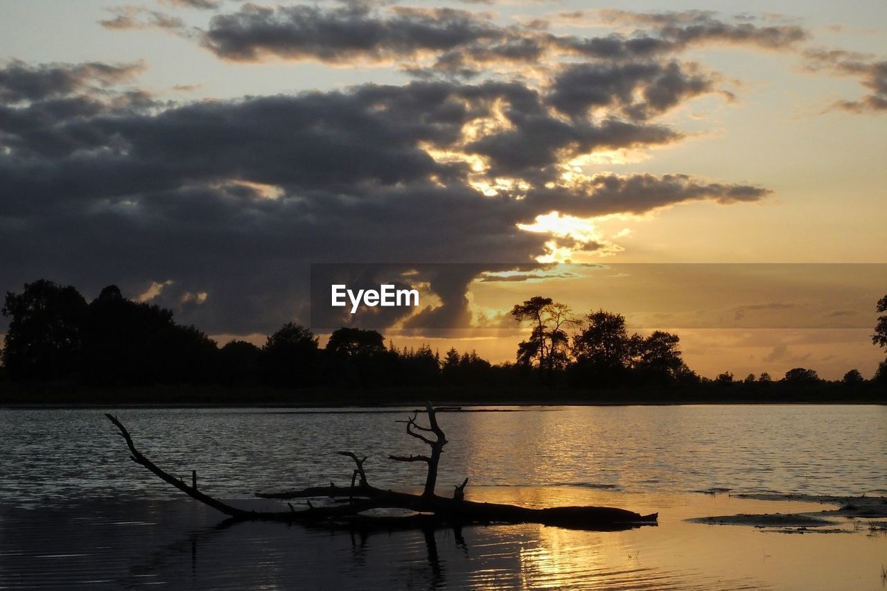 SCENIC VIEW OF LAKE AGAINST SKY AT SUNSET