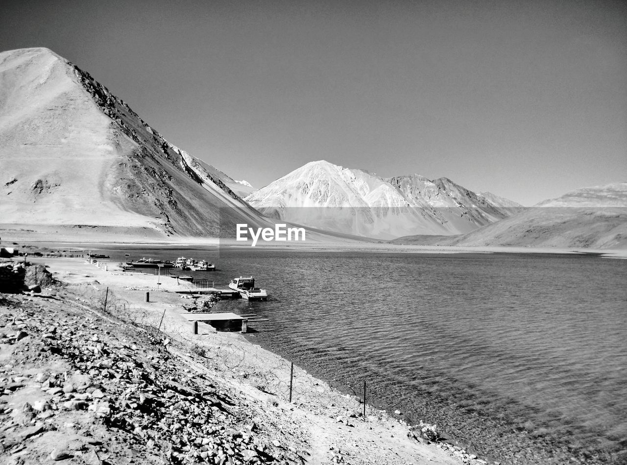 Scenic view of lake and snowcapped mountains against clear sky