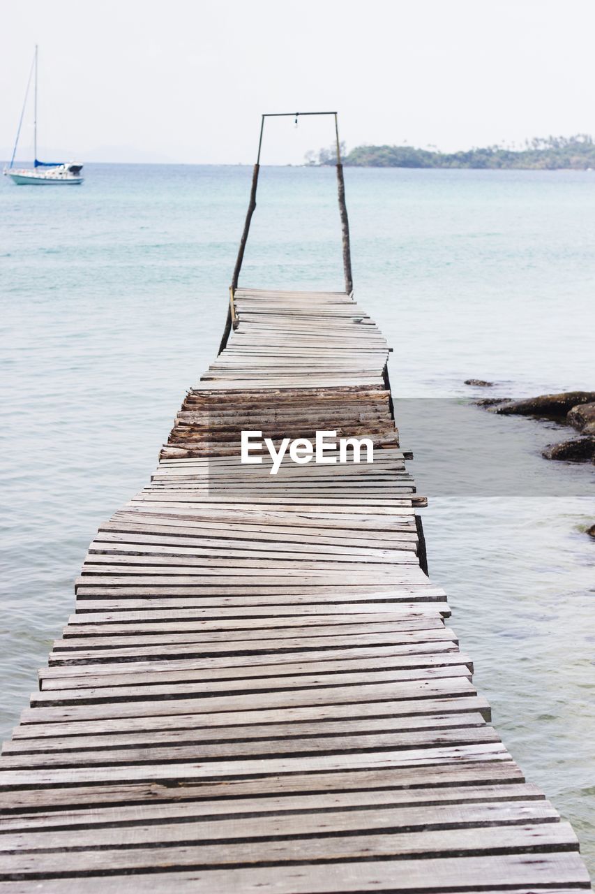 Wooden pier on sea against sky