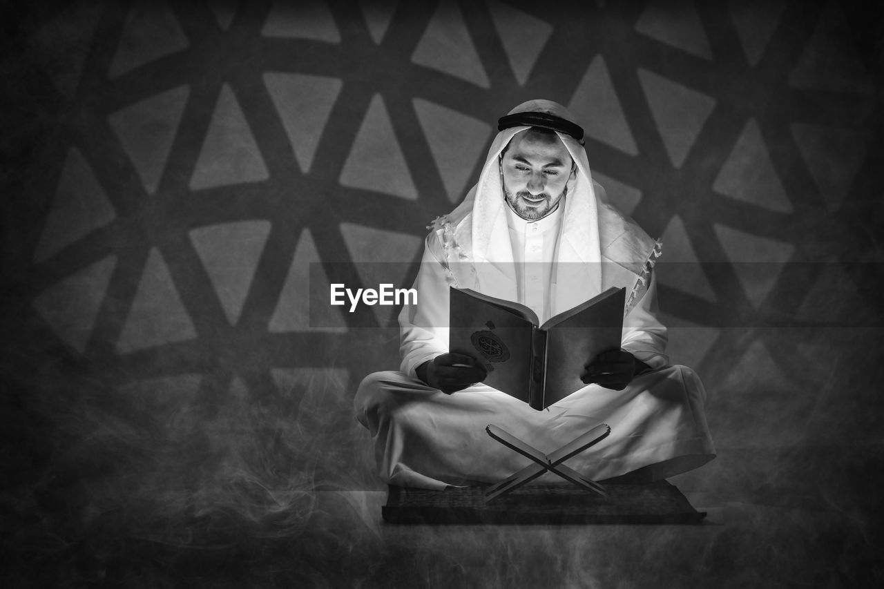 PORTRAIT OF MAN HOLDING BOOK