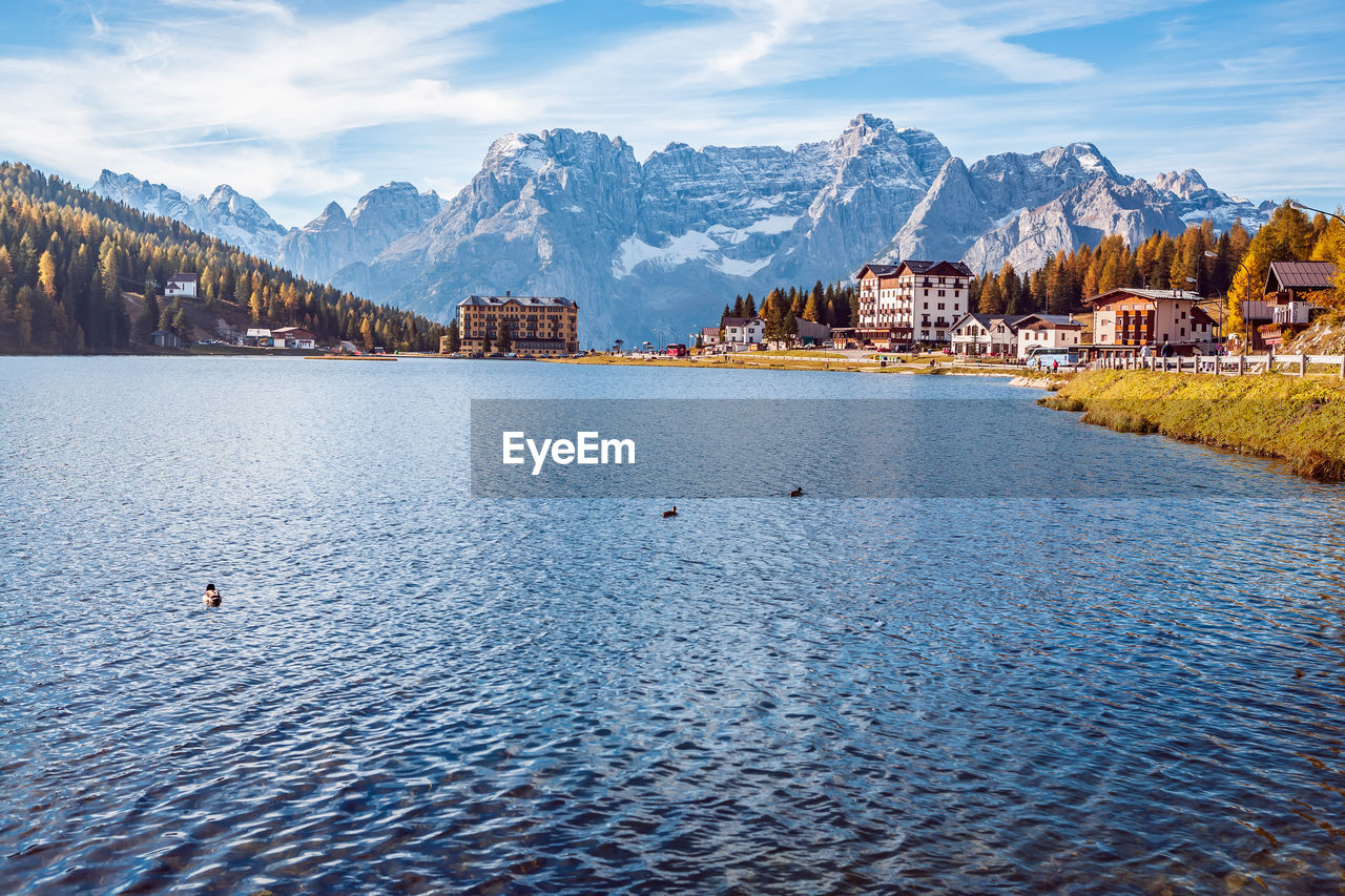 Scenic view of lake by buildings against sky