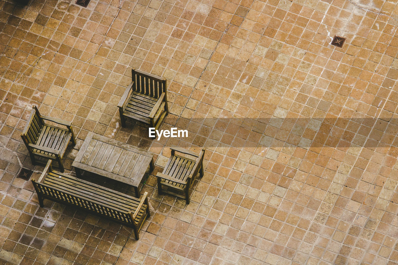 High angle view of empty chairs and table on footpath