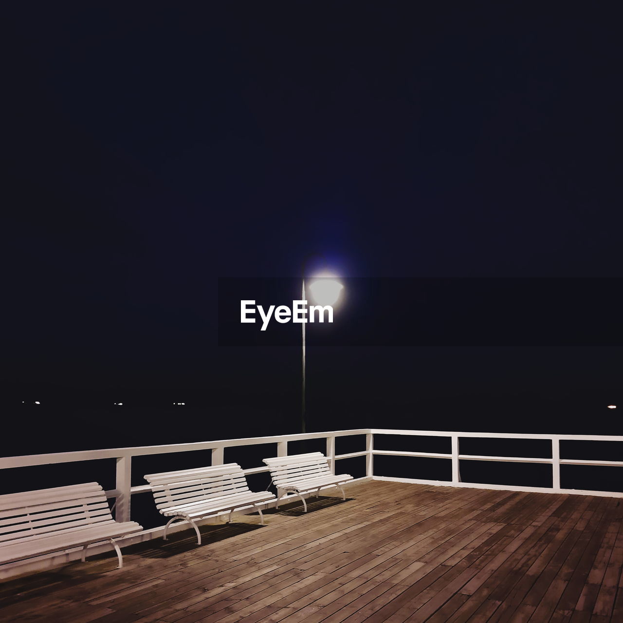 EMPTY SEATS ON TABLE AGAINST ILLUMINATED LIGHTS