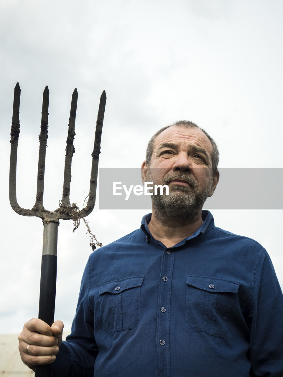 Male farmer with a pitchfork in his hands