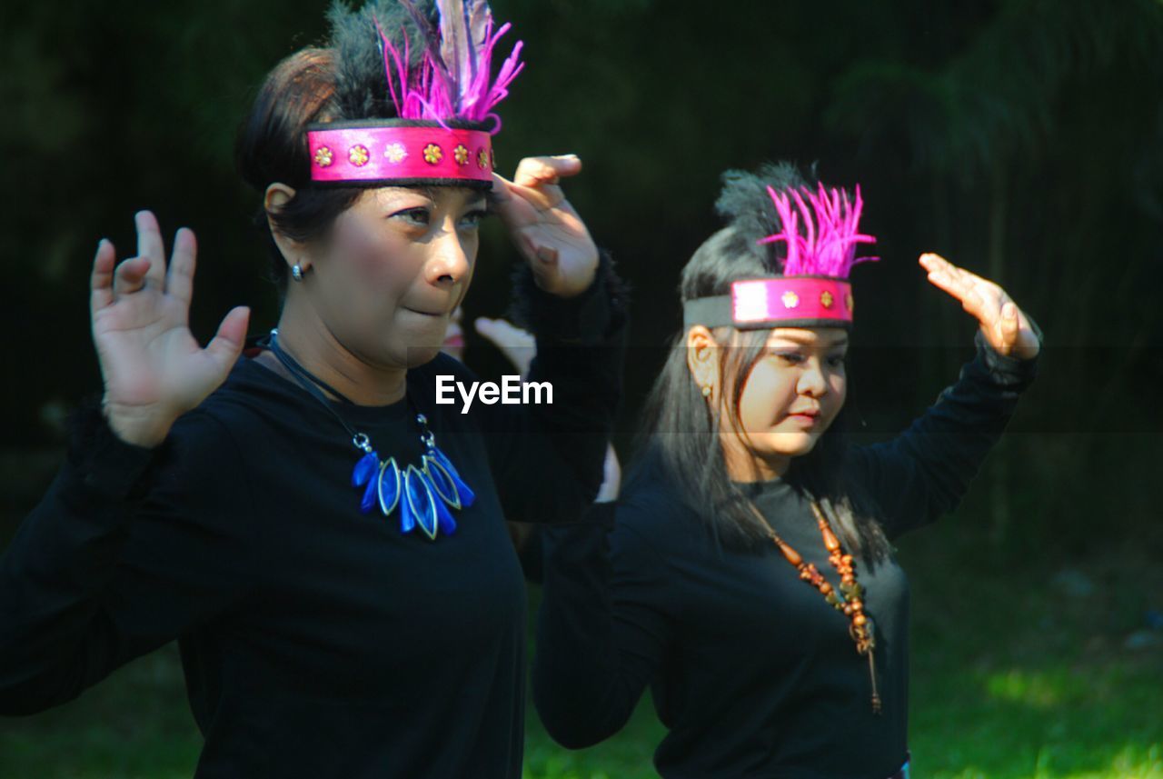 Young females dancing on grassy land