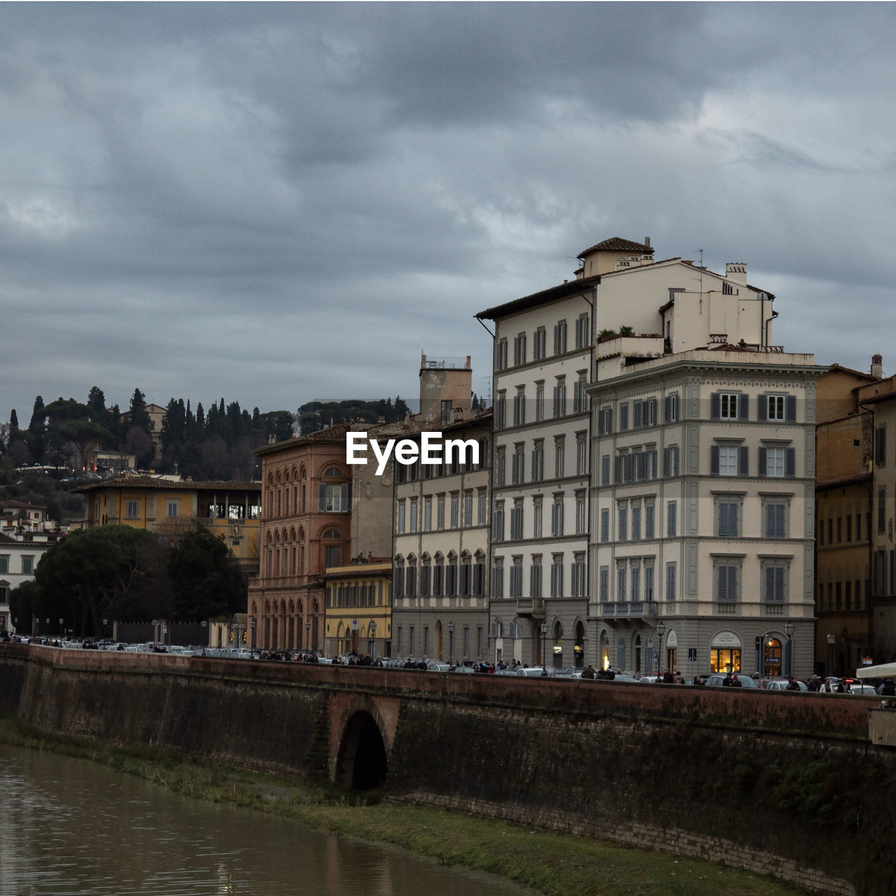 ARCH BRIDGE OVER RIVER BY BUILDINGS AGAINST SKY