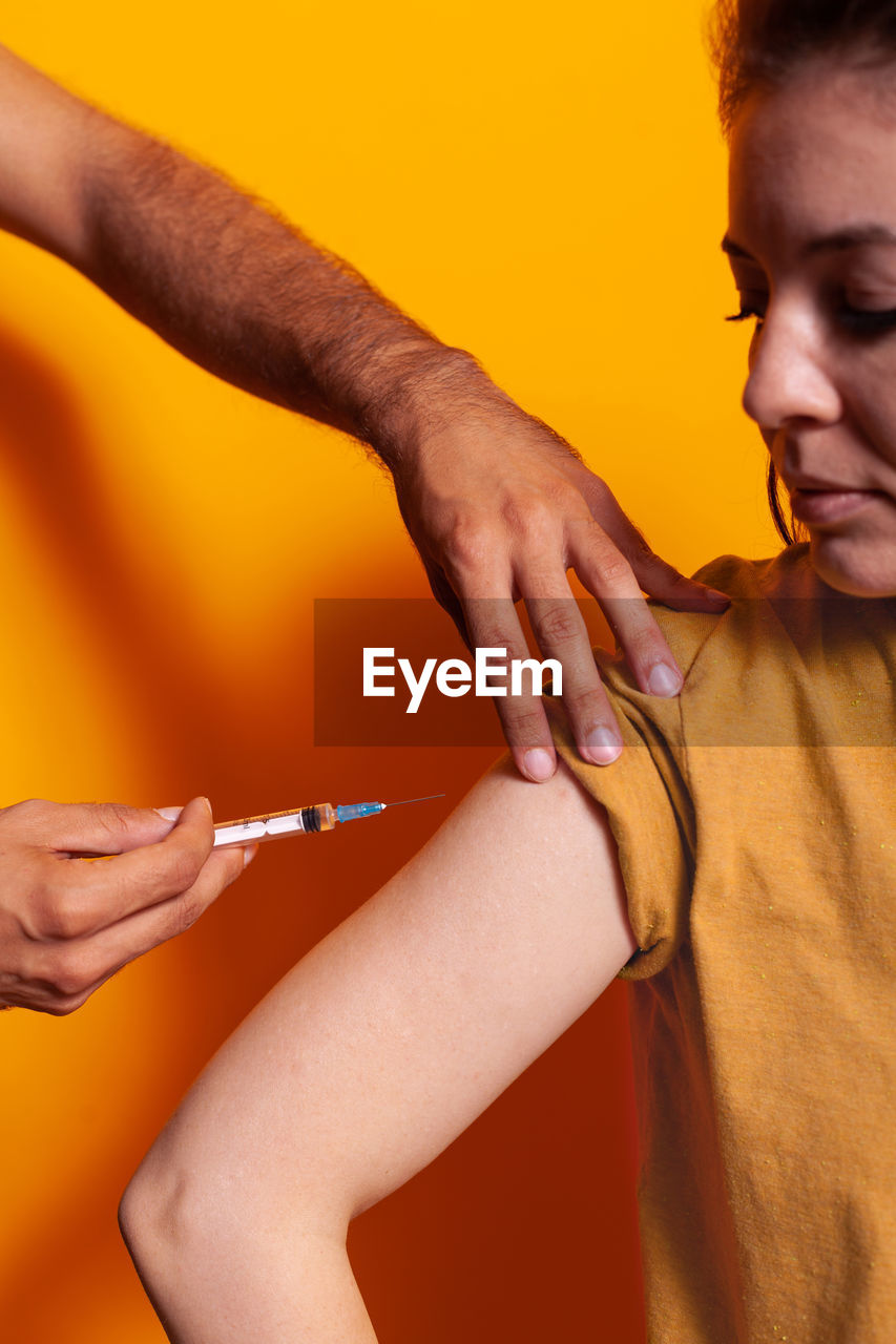 Cropped hand of doctor vaccinating patient