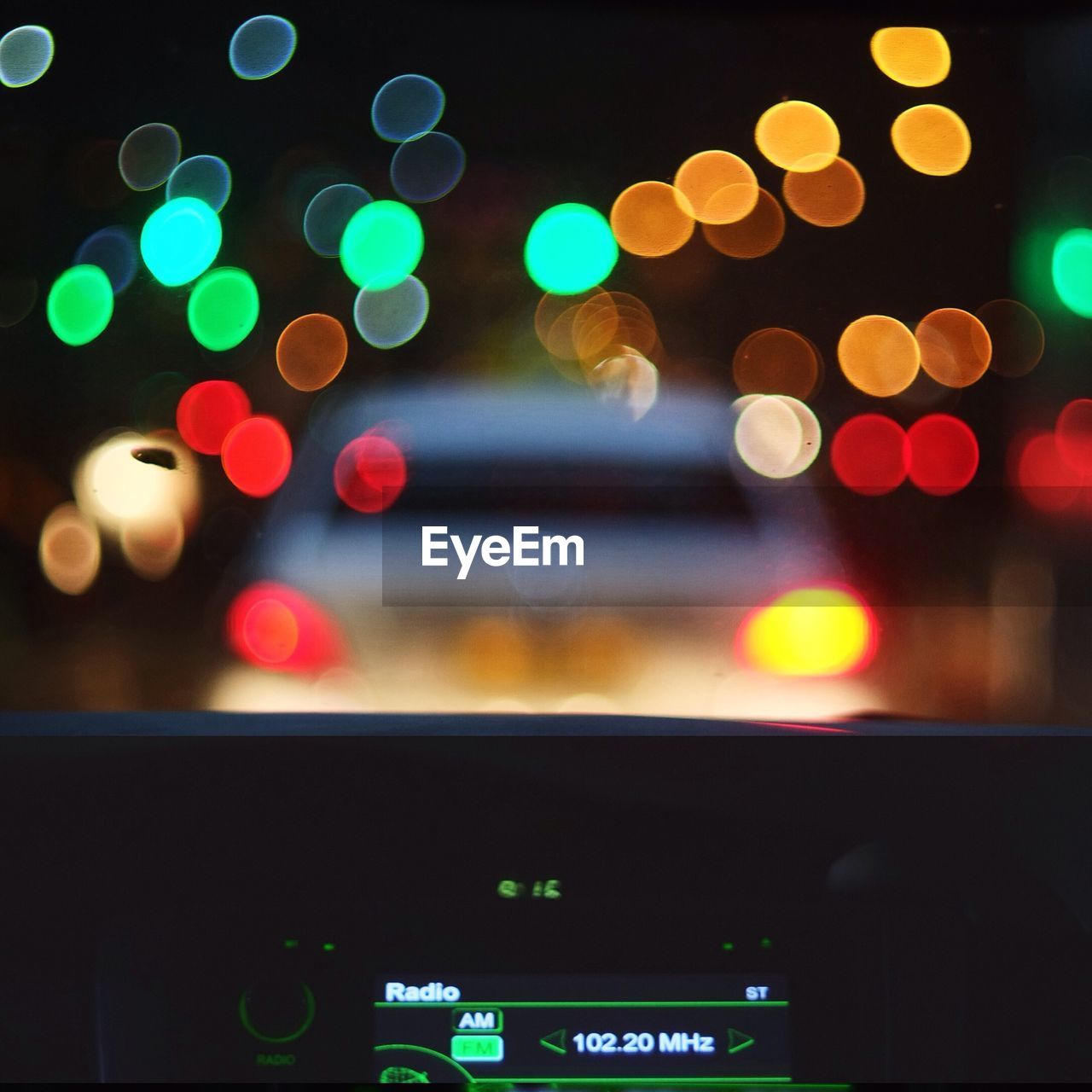 Defocused image of lights at night seen through car windshield