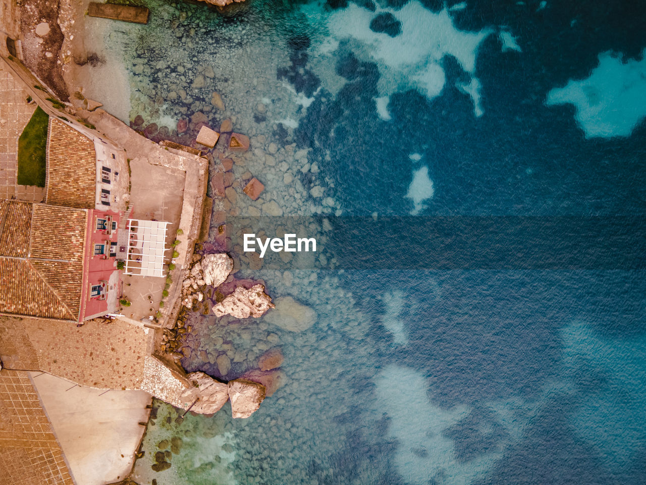 HIGH ANGLE VIEW OF SWIMMING POOL BY BUILDING AT SEA