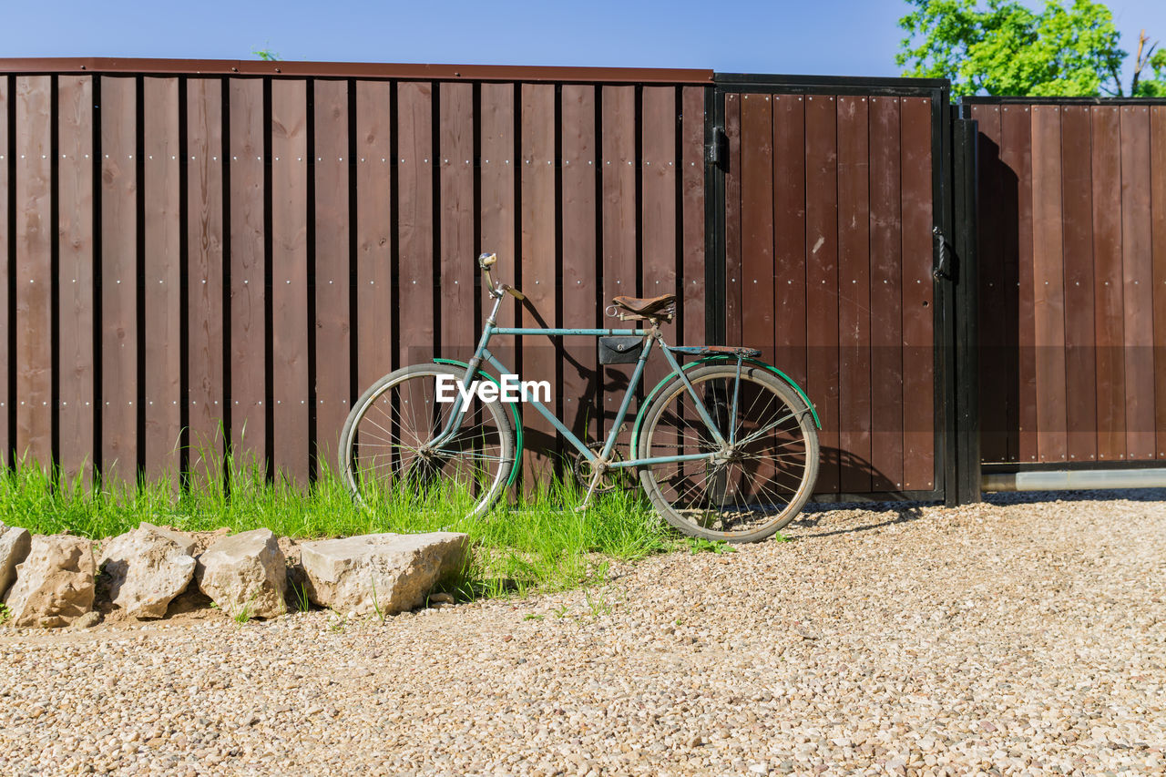 Old bicycle parked at a wooden fence, countrycide landscape