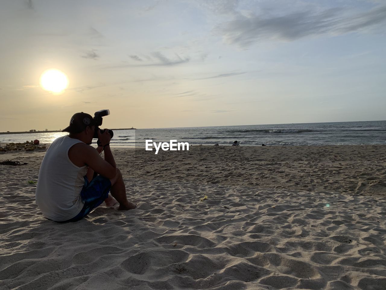 WOMAN PHOTOGRAPHING ON BEACH