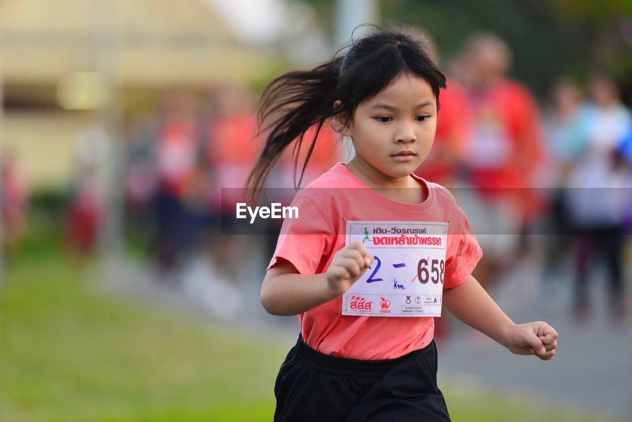 FULL LENGTH OF GIRL STANDING AGAINST BLURRED MOTION